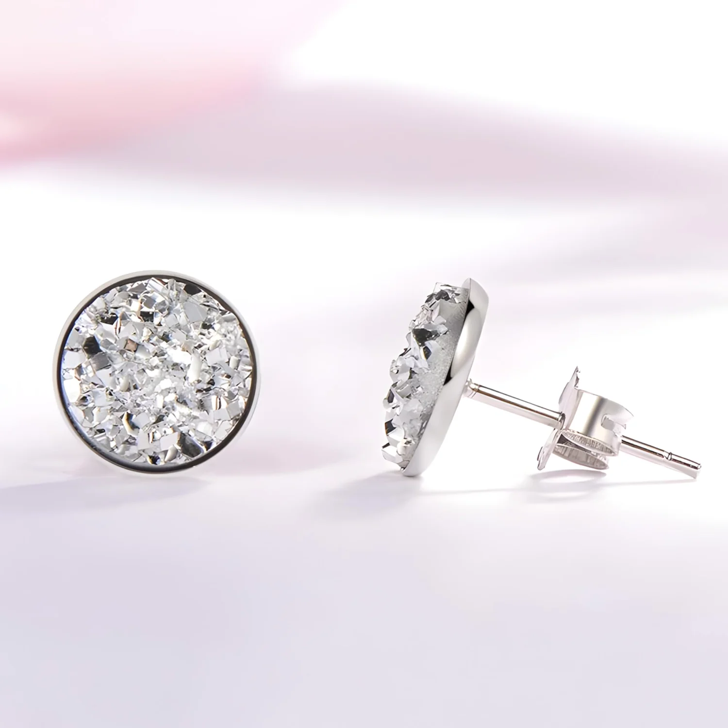 Round silver stud earrings worn in a lobe