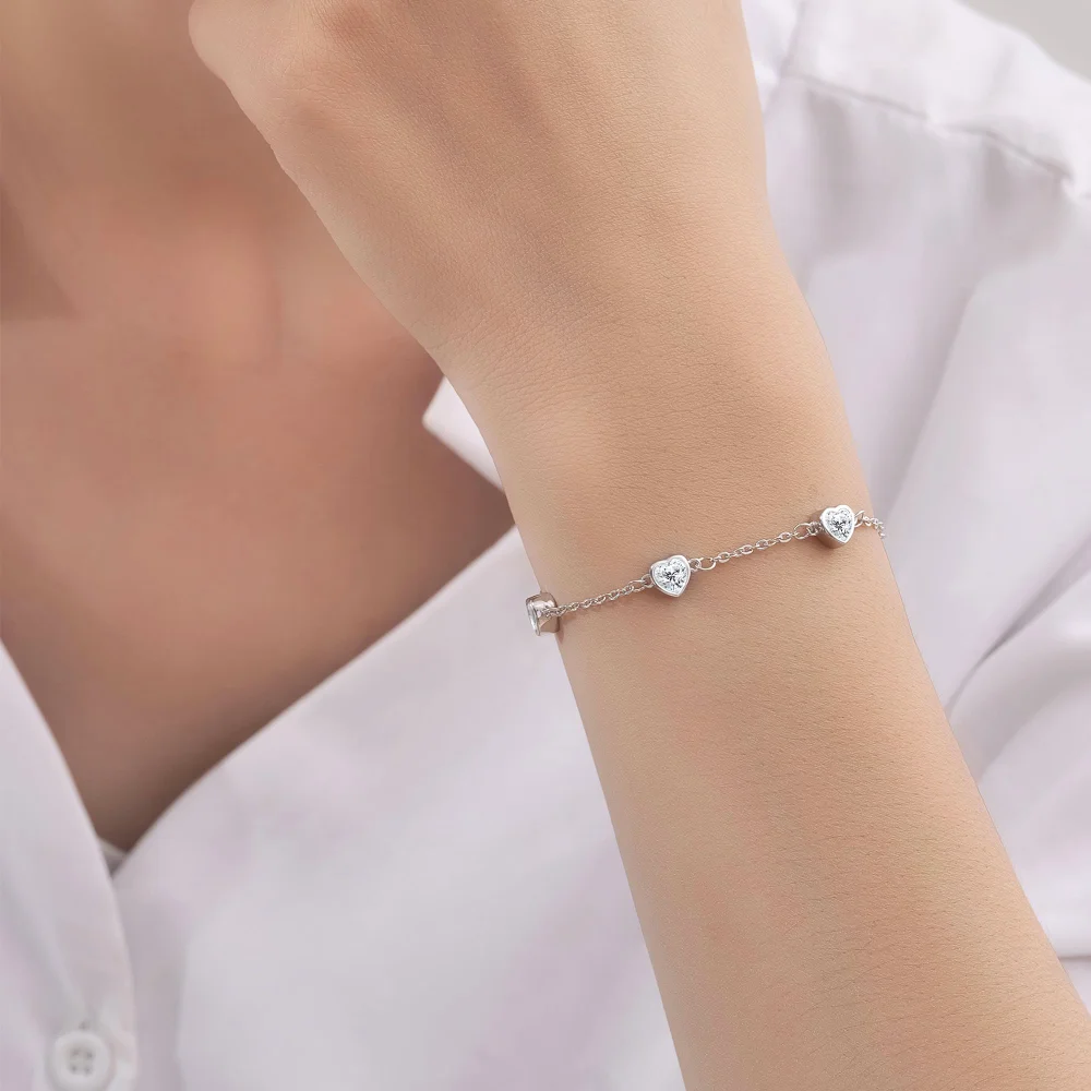 The heart birthstone bracelet on a wrist, clasp to the outside